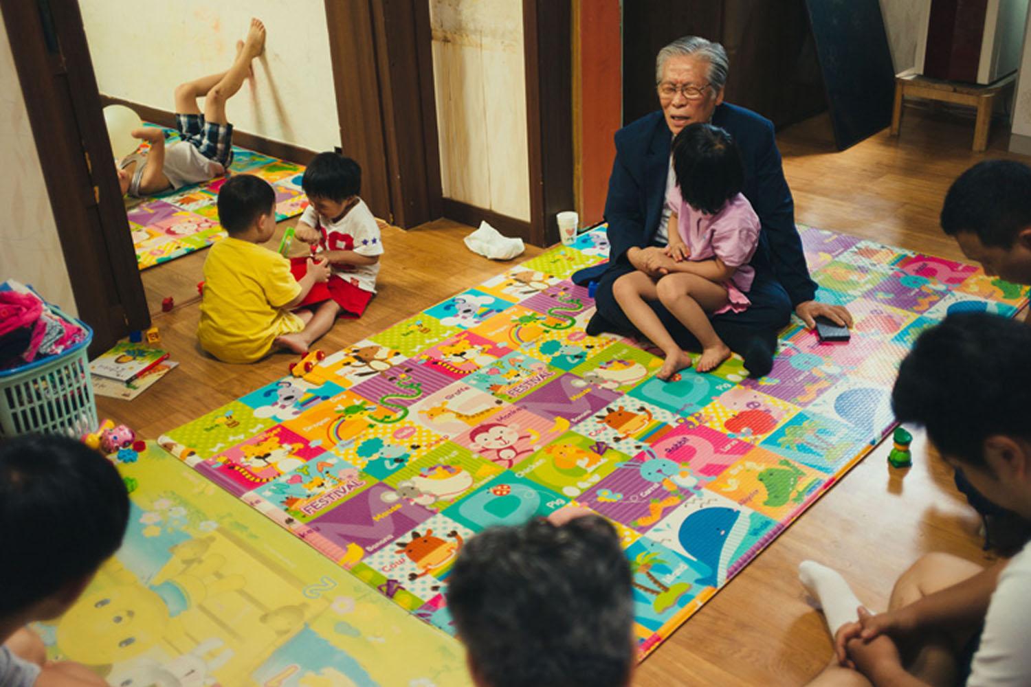กลุ่มเด็กกำลังนั่งเล่นกับผู้ดูแลบนแผ่นรองพื้นในศูนย์เลี้ยงดูเด็กที่ก่อตั้งขึ้นในเกาหลีใต้เพื่อช่วยเด็กทารกที่ถูกละทิ้ง Cr. Lozierinstitute