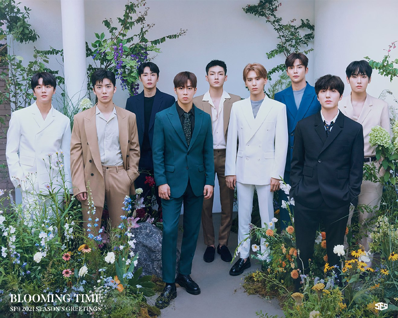 SF9團體照，身穿正式西裝在花園背景前