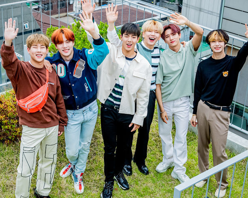 MONSTA X團體照，黑色服裝在搖滾風格背景前合影