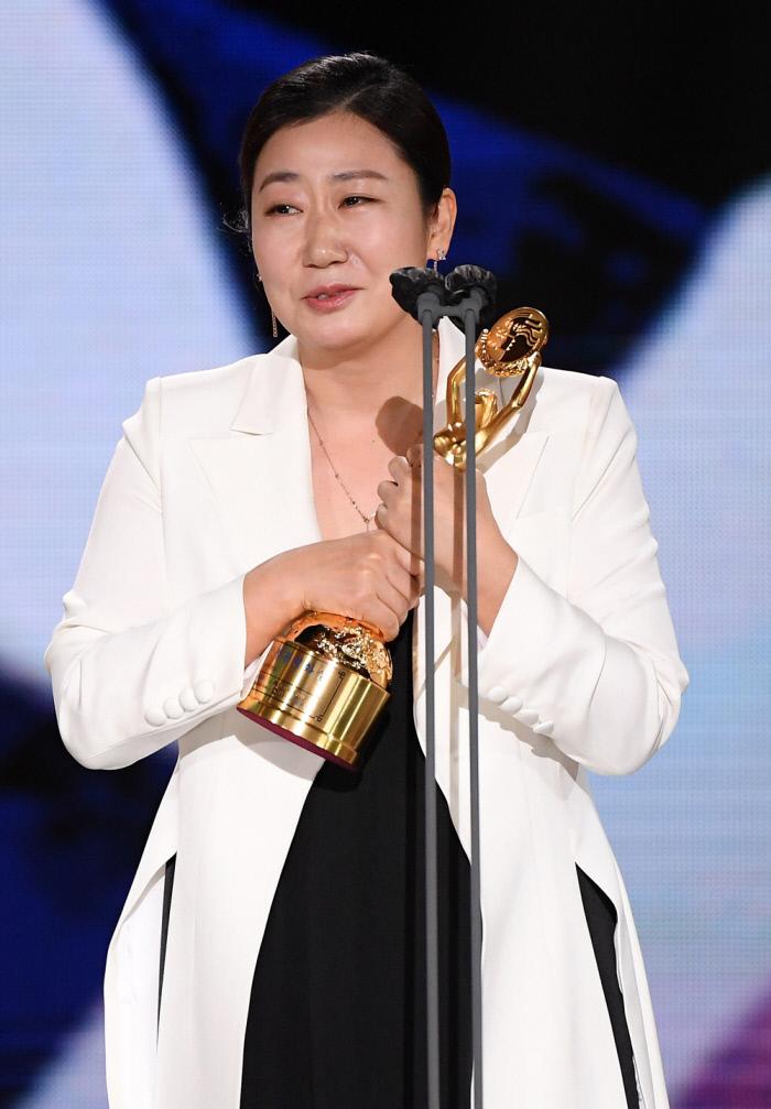 第41回青竜映画賞で主演女優賞を受賞し、トロフィーを抱く女優。受賞の感慨を胸に、壇上で感謝の言葉を述べている。