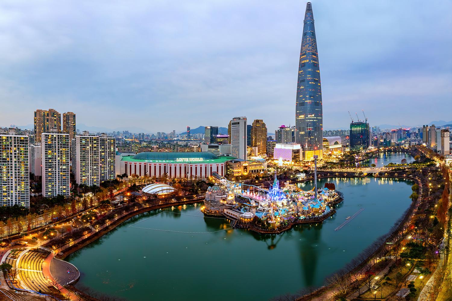 Vista panoramica della Lotte World Tower e del parco nelle vicinanze a Seoul durante il tramonto.