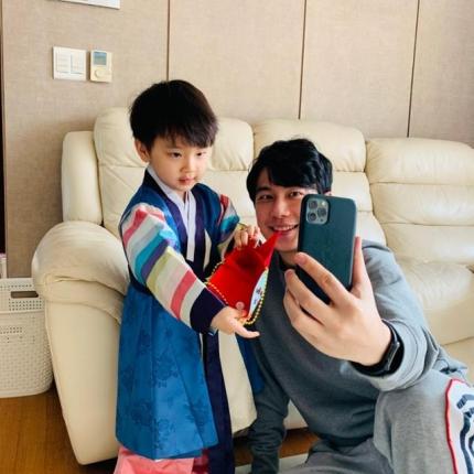 韓国の旧正月に非対面で祖父母と話す子供、ソン・ハユン君が攜帯を見ながら韓服を着ている様子。