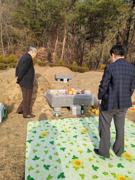 韓国の墓地でのお墓参りの光景、順番に訪れる家族の姿。