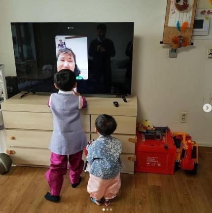 ソウルのパク・ソジンとジワン君がテレビ越しに祖父母に挨拶する姿。旧正月に韓服を着てテレビ電話を利用する様子。