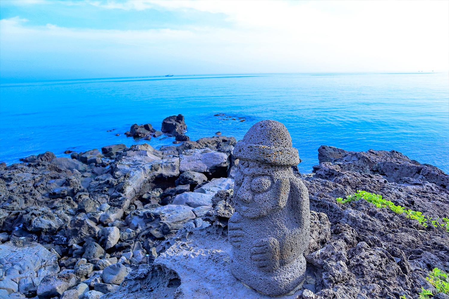 รูปปั้นหินดอลฮารูบังที่เป็นเอกลักษณ์ของเกาะเชจูบนชายหาด