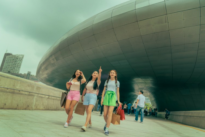 to all the boys: always and forever lara jean, margot, and kitty holding shopping bags and  walking at dongdaemun design plaza