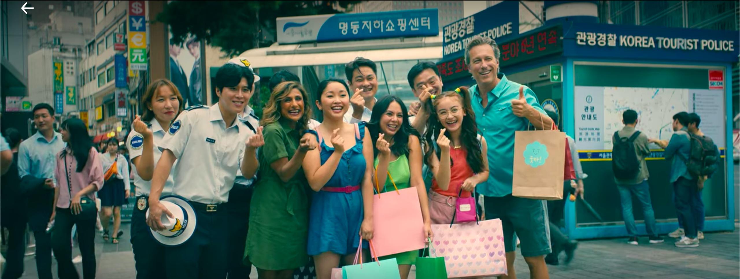 to all the boys: always and forever lara jean, margot, kitty, dan, and trina with korean tourist police posing with finger hearts in myeongdong shopping district