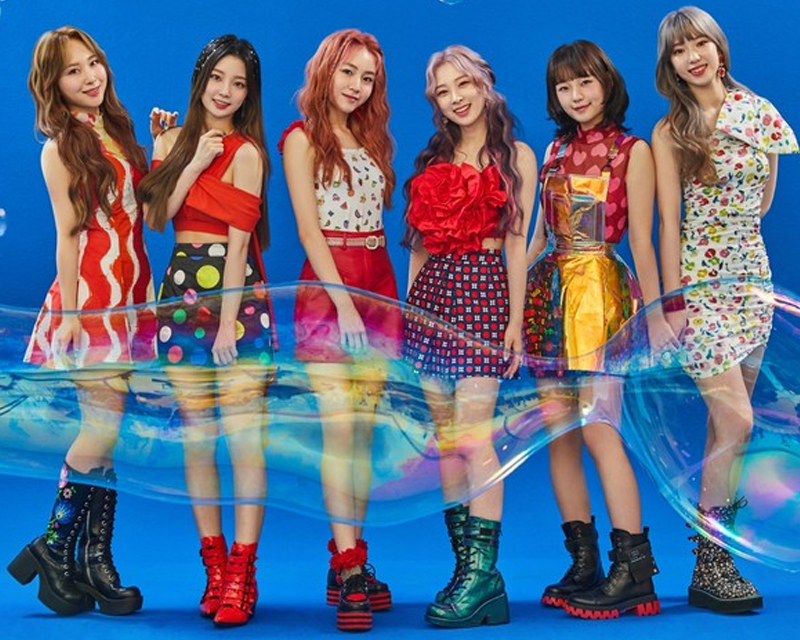 Rocket Punch 團體照片，成員穿著色彩鮮豔的舞台服裝，背景顏色為藍色
