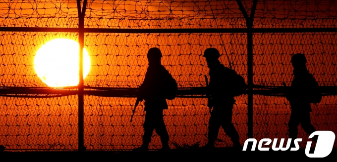 日落時分，軍人在非軍事區的鐵絲網附近進行巡邏，展示南北韓之間的嚴密警戒。