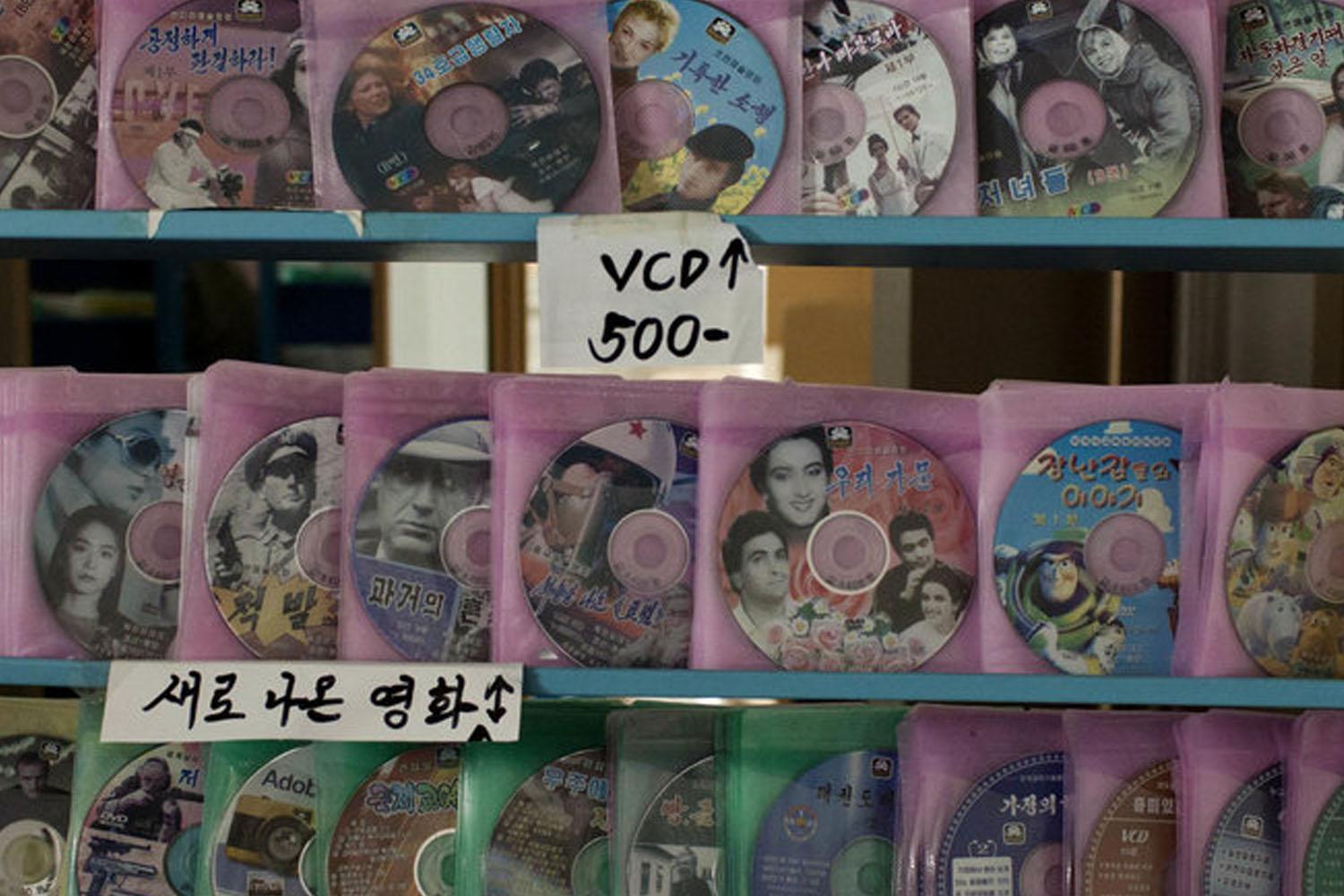 แผ่นซีดีภาพยนตร์วางเรียงในที่วาง, สะท้อนการกระจายสื่อภาพยนตร์ในท้องถิ่นทั้งจากต่างประเทศและภายในประเทศ เกาหลีเหนือ