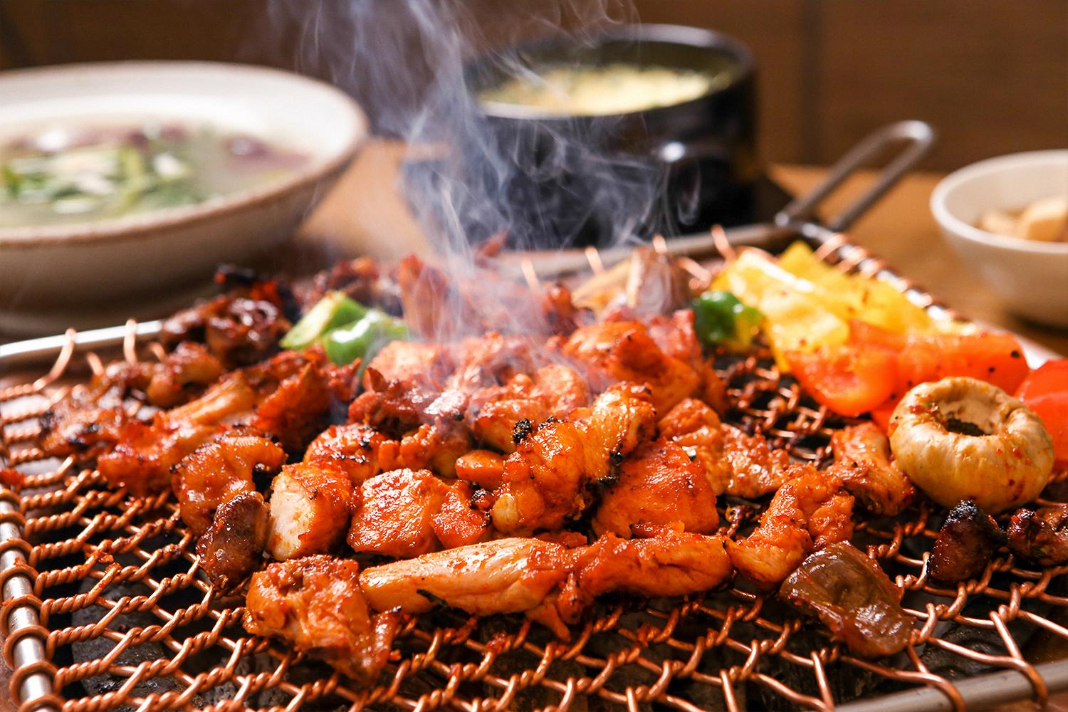 Dakgalbi, ayam tumis pedas, hidangan khas dari Chuncheon, Korea Selatan di atas panggangan.