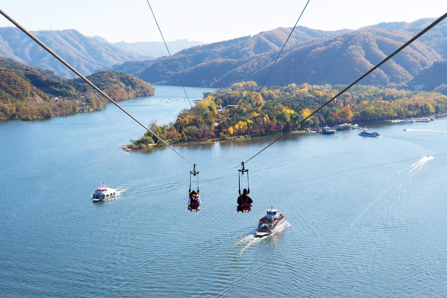 Namiseom Zip Wire di Pulau Nami, Gapyeong, menawarkan sensasi terbang di atas air dengan latar belakang pegunungan.