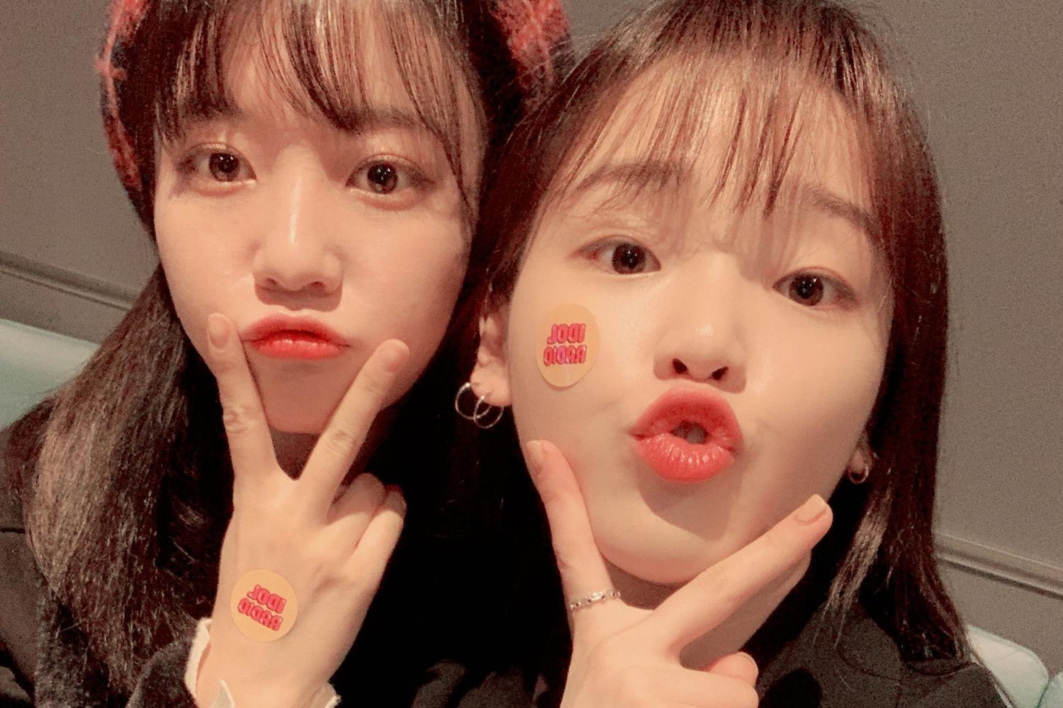 Dua anggota OH MY GIRL saat berpose bersama, latar belakang di Korea Selatan.