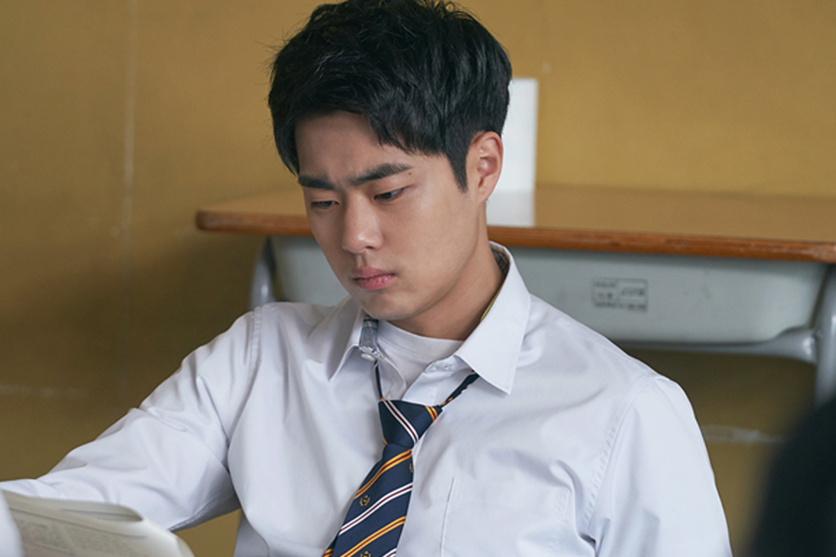 赵炳圭在电视剧《天空之城》中的剧照，表现出角色在课堂中专注学习的时刻，身着白色衬衫和学校领带。