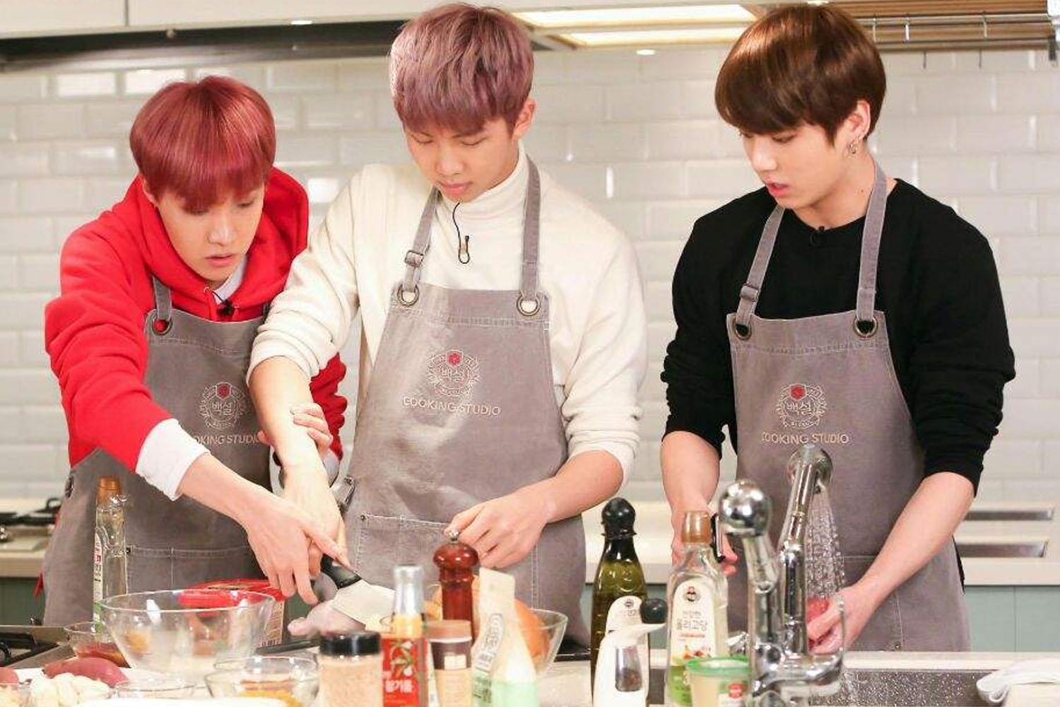 三位成員在廚房工作室攪拌碗裡的材料，愉快地參與共同烹飪活動。