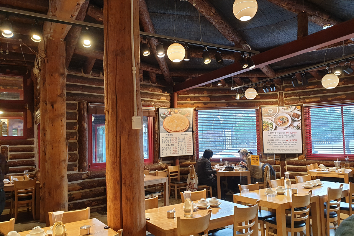 다람쥐 마을 누룽지백숙의 실내 사진으로, 원목 인테리어와 테이블들이 배치된 모습입니다.
