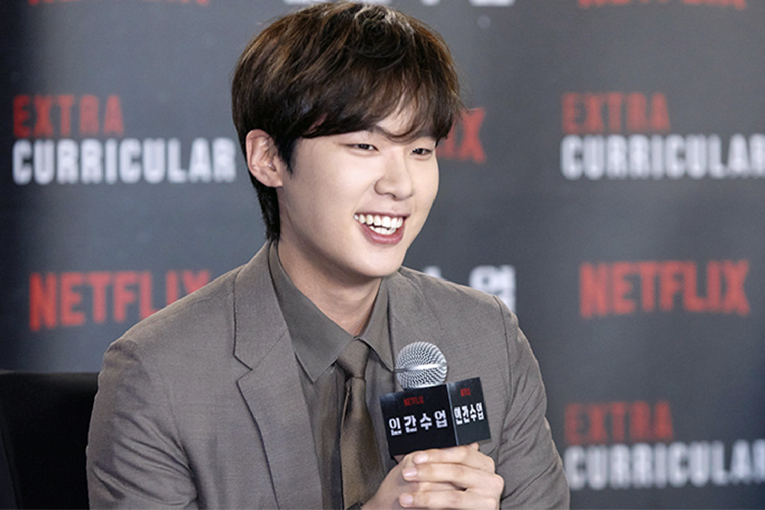 韓劇《人性課外課》宣傳活動中的一位男演員。背景有Netflix的logo和劇集名稱。