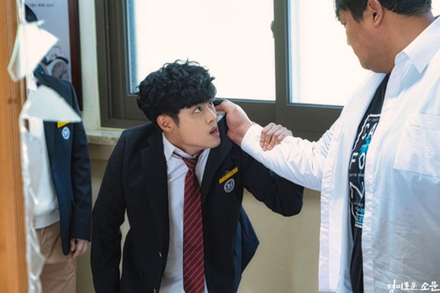 นักเรียนชายเกาหลีใต้ในเครื่องแบบดูตกใจหรือทะเลาะกัน ฉากนี้เกี่ยวข้องกับปัญหาการกลั่นแกล้งในโรงเรียน