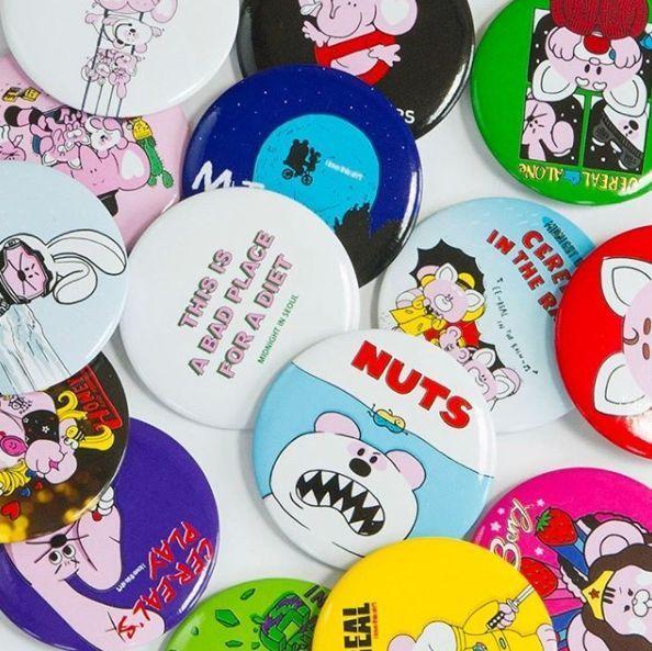 Collection of colorful badges from Midnight in Seoul café, each with unique designs reflecting the café's quirky style.
