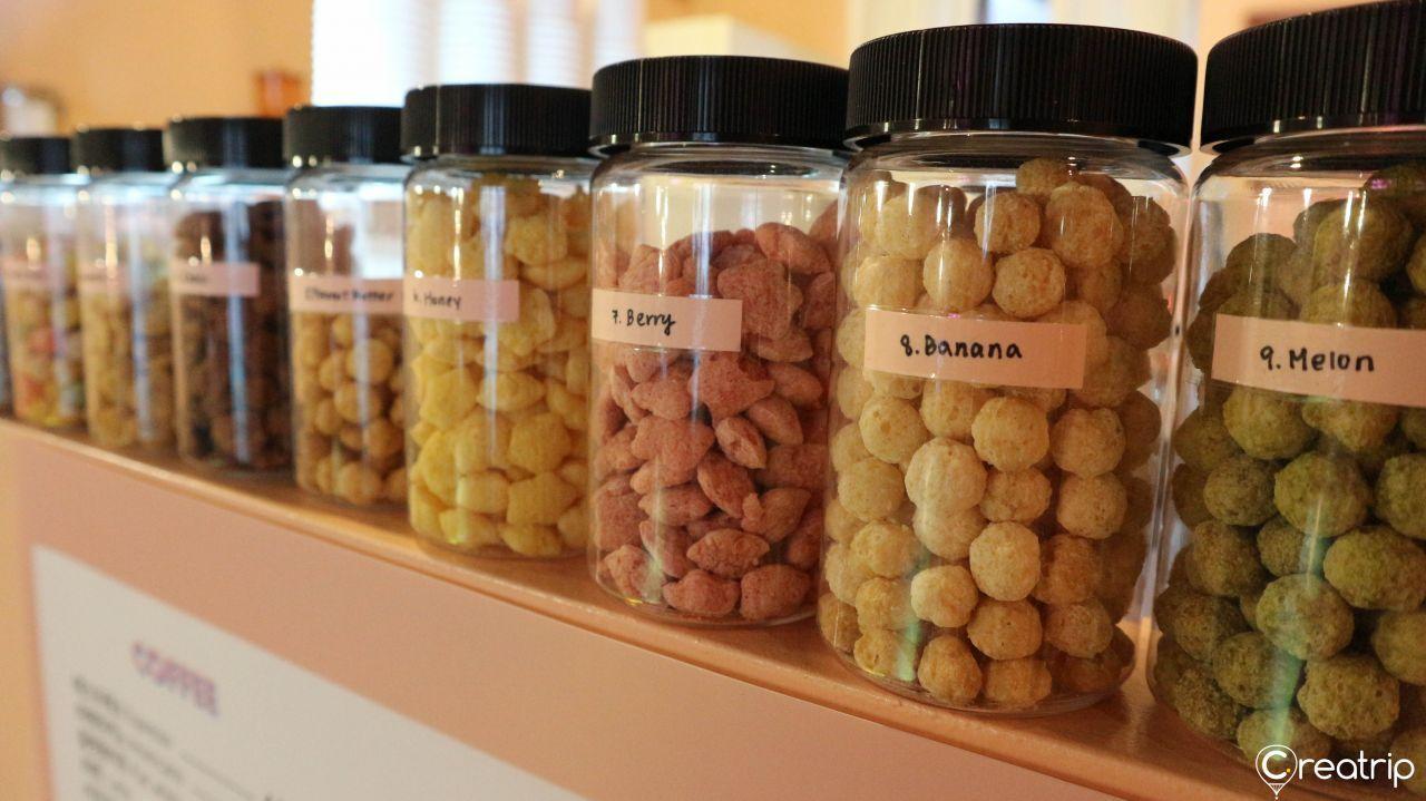 Cereal and topping serving area in Midnight in Seoul, enticing visitors with diverse and inventive cereal options.