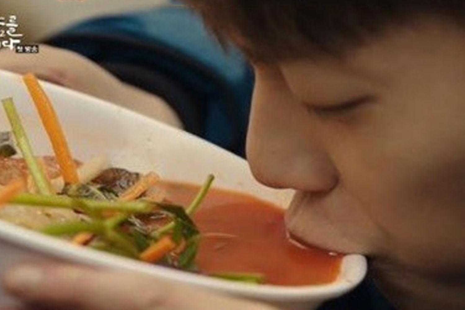 บะหมี่ร้อนในชามที่จัดเสิร์ฟ พร้อมกับผักสดหลากชนิดกำลังราดด้วยซุปของเกาหลี แสดงให้เห็นถึงวัฒนธรรมการกินเกาหลีที่มีเอกลักษณ์และเต็มไปด้วยรสชาติ.