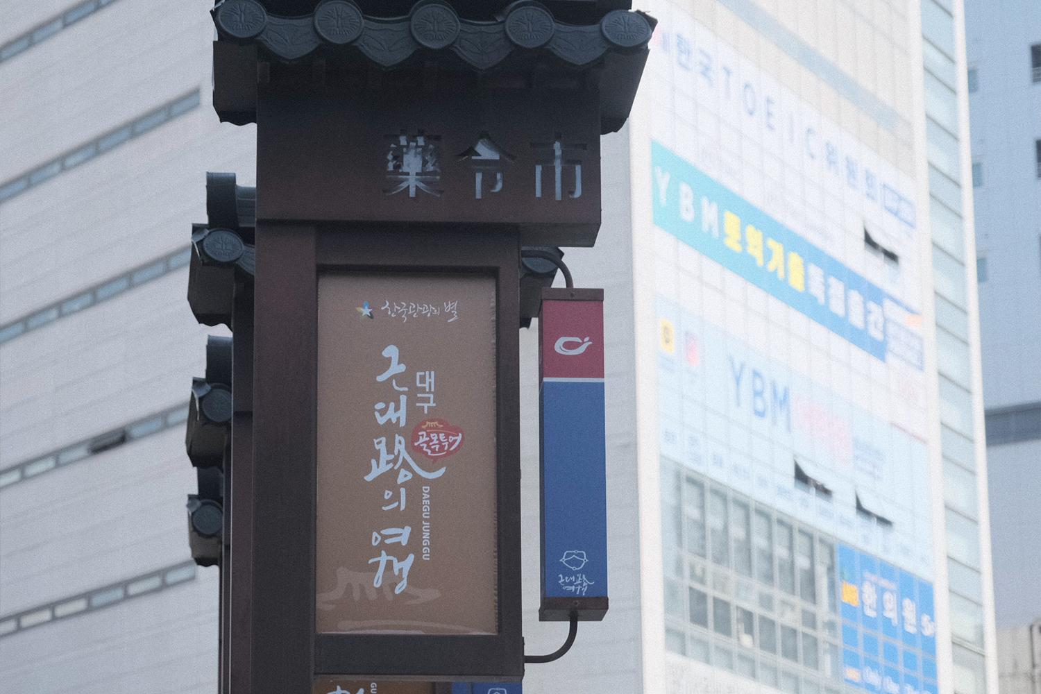 韓國大邱近現代衚衕麵包店的指示牌，背景可見商業建築。