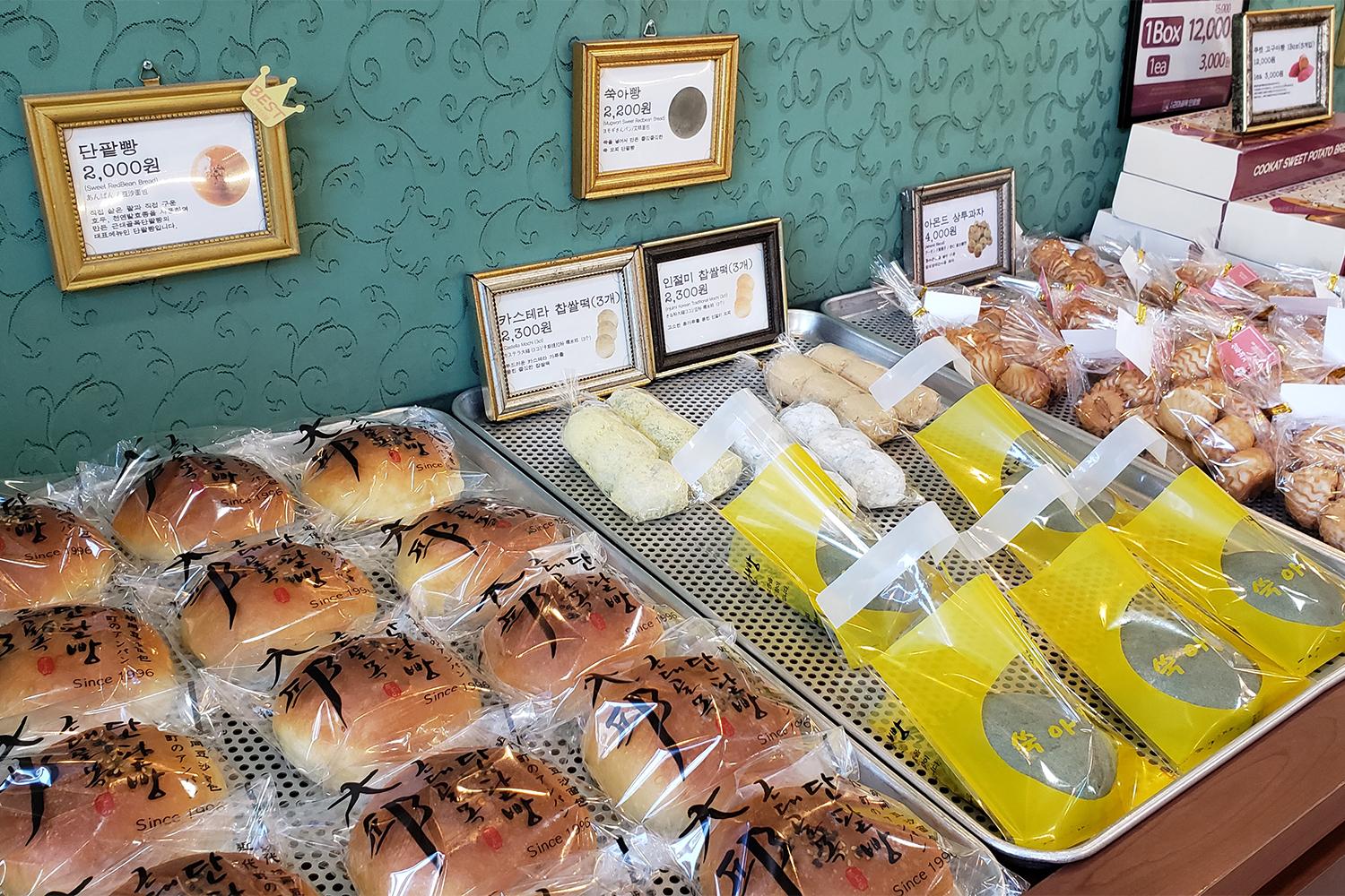 近代衚衕紅豆麵包店內整齊陳列的糕點，透過櫥窗展示多種選擇。