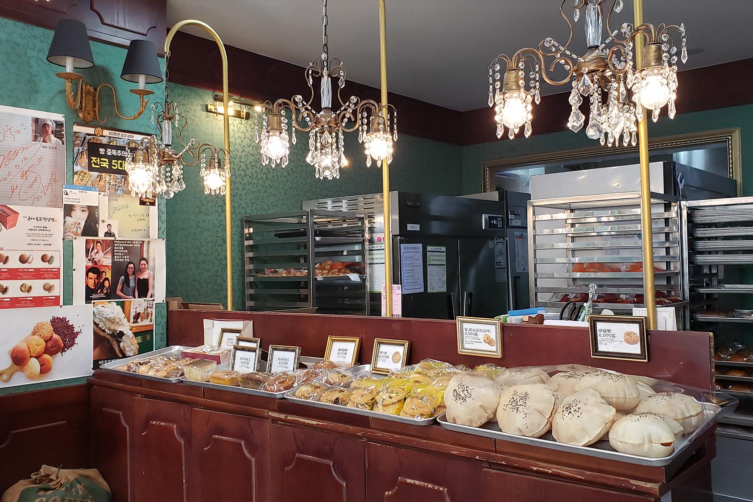 韓國大邱紅豆麵包店的內部，展示多種精美糕點，吊燈增添古典氛圍。