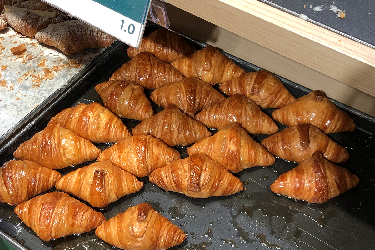 一盤充滿亮澤感的楓糖牛角包，展示於克拉商店的餐廳櫃台。