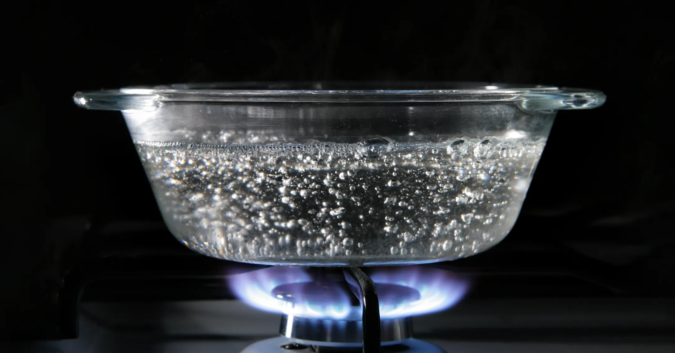 pot of water on gas burner with water bubbles to indicate boiling