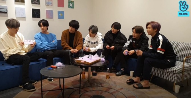 members of bts sitting on sofas
