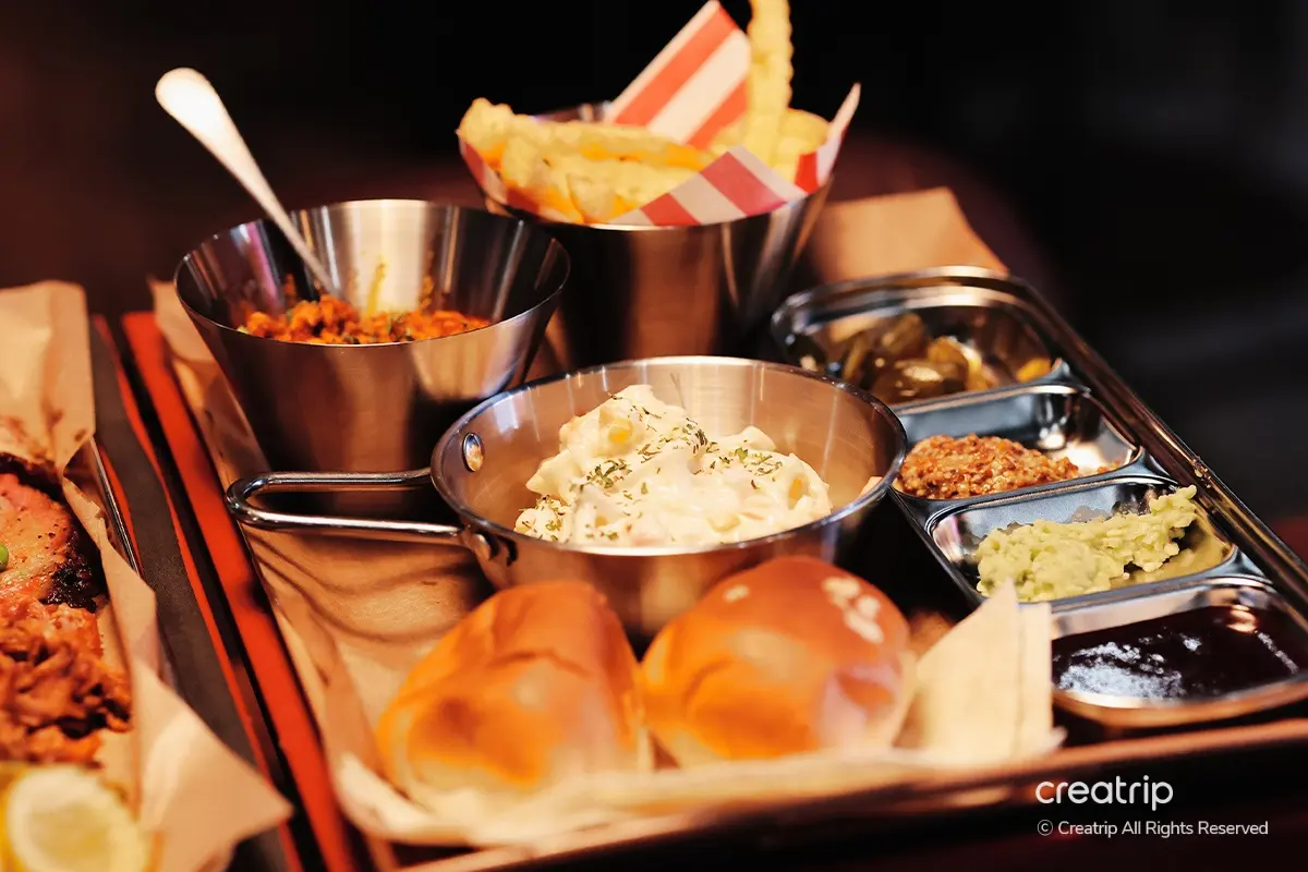 Assorted side dishes served at Ghost Black in Yeonnam-dong, including crispy fries, refreshing salad, pickles, and soft bread rolls, creating a balanced meal with delightful textures and flavors.