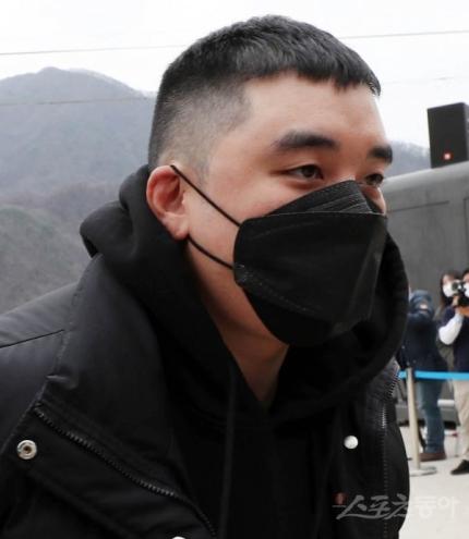 裁判所の屋外で、黒いパーカーを着用した男性。