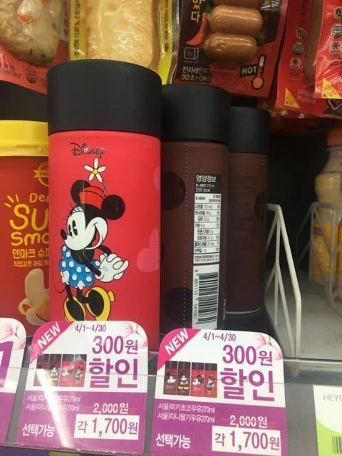 Close-up of Seoul Milk Minnie Mouse bottle with promotional signage displayed at CU convenience store, showing new character designs and flavors for the spring season.