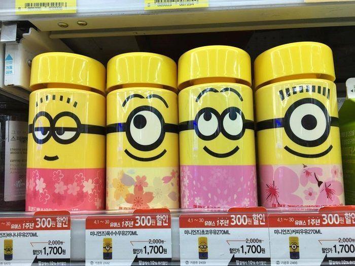 Four Minions-themed milk bottles with yellow caps and floral designs available at a GS25 store, promoting seasonal flavors with a 300 Korean won discount, spring theme.