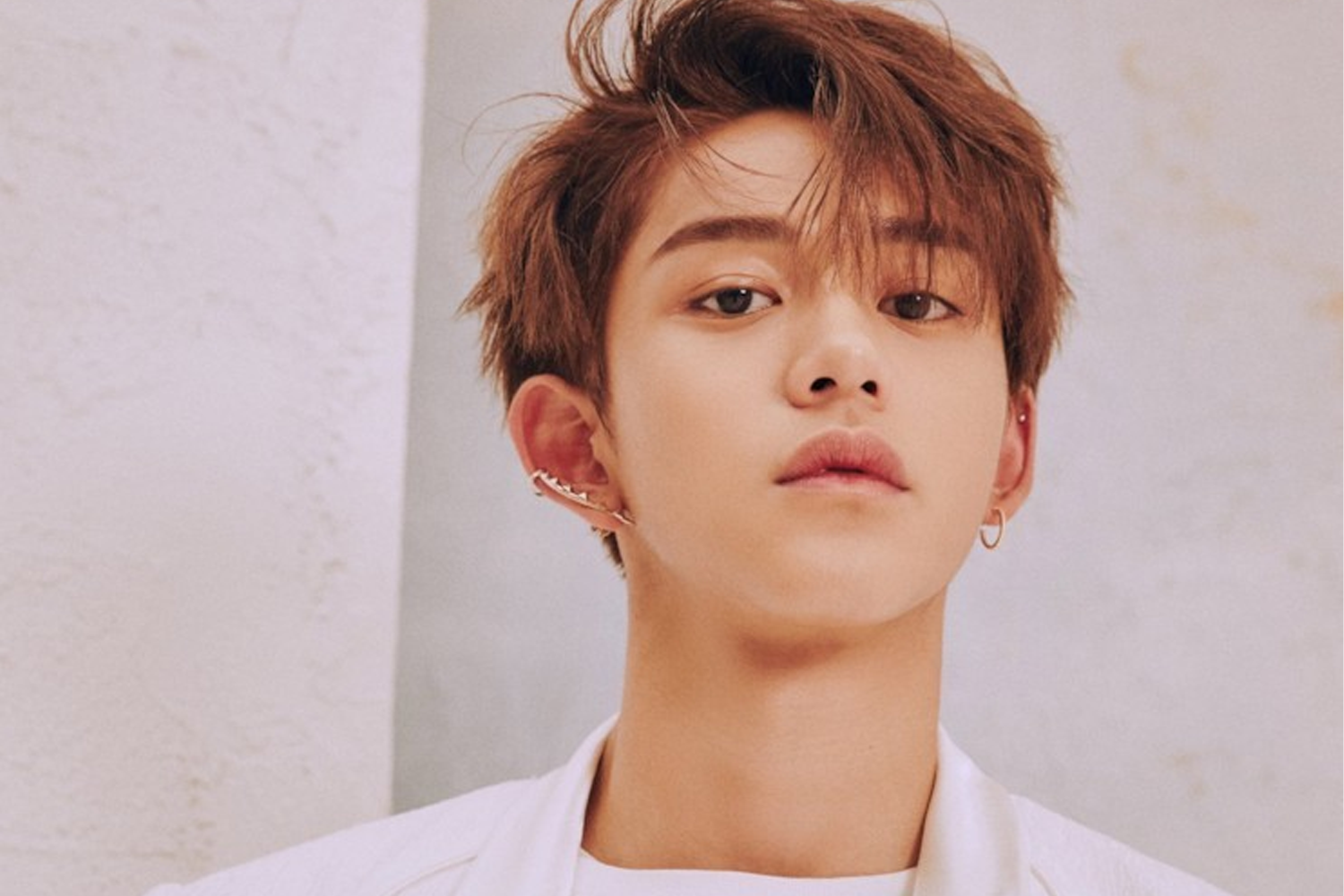 此圖展示了香港男藝人的時尚造型，他身穿時尚服飾，用耳環修飾，呈現摩登都市風采。