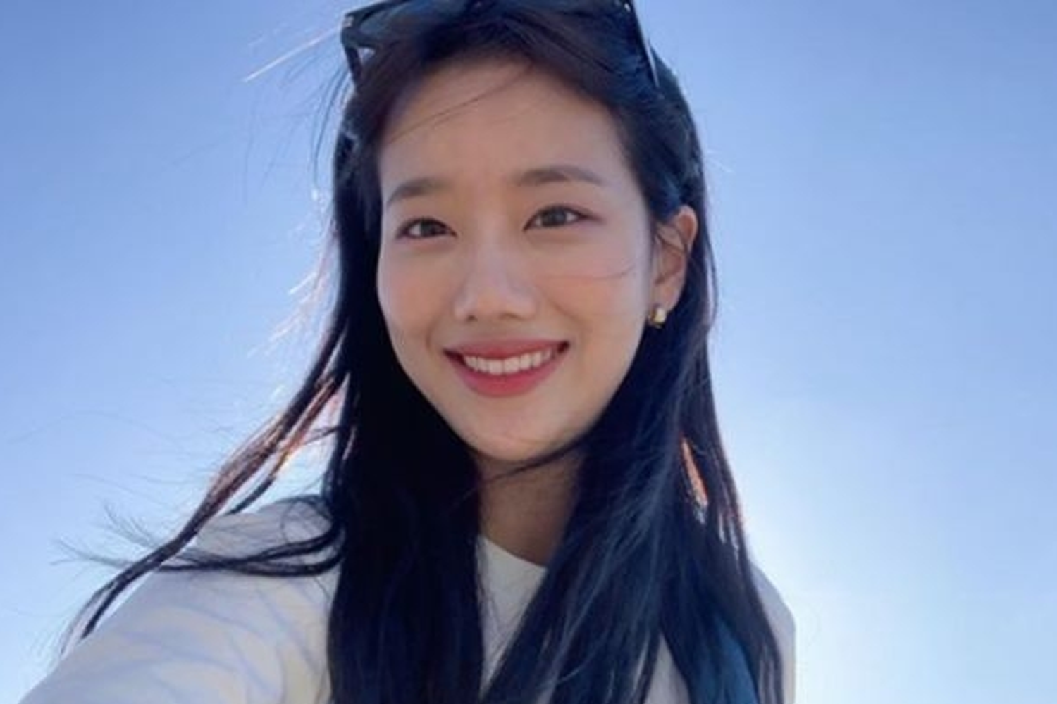 APRIL成員娜恩在藍天背景下，隨著陽光輕輕拂過，瀰漫著自由與愜意的氛圍。