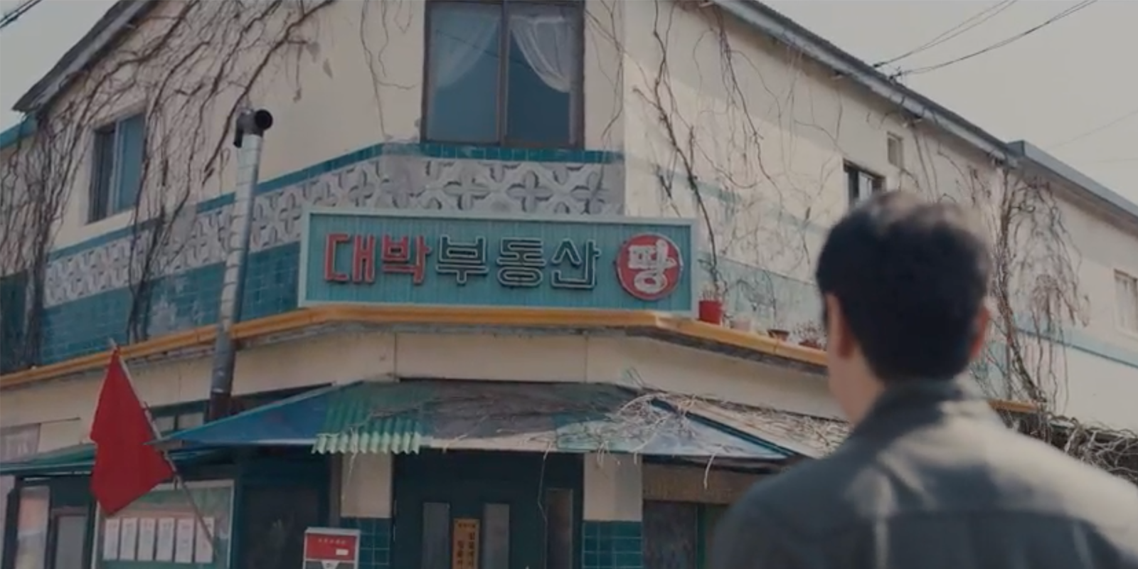 白天大發不動產的外觀，牆上攀附著藤蔓，帶有復古風情