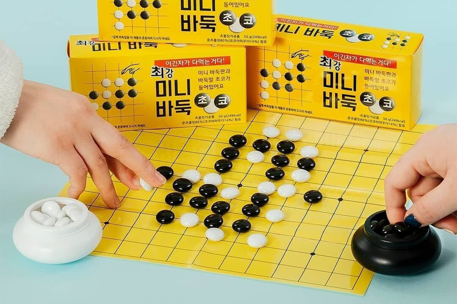 초코 바둑 게임 보드 위에서 초코 바둑알을 사용해 체스를 두는 모습.