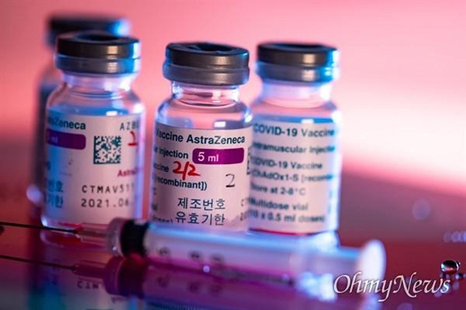 阿斯利康(AstraZeneca) COVID-19 疫苗小瓶中的針筒，背景呈粉紅色，來源: OhmyNews