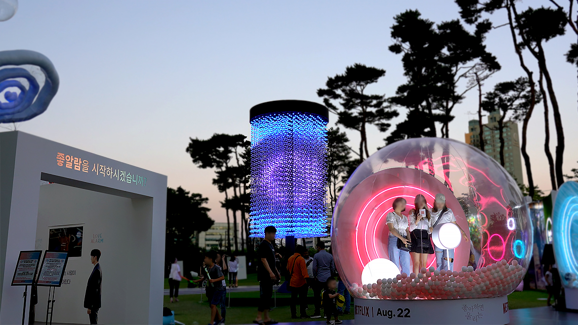 พื้นที่จัดแสดงเปิดของ Love Alarm ในเกาหลีใต้ มีแสงสีสว่างตอนเย็น.