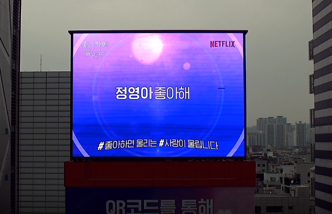 ข้อความแสดงบนจอขนาดใหญ่ในกรุงโซล โปรโมท Love Alarm ซีรีส์เกาหลีบน Netflix.