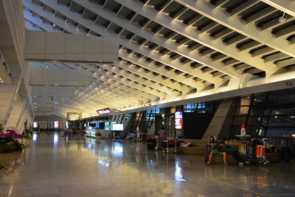 韩国机场的现代建筑与交通指示牌，显示繁忙的机场环境。