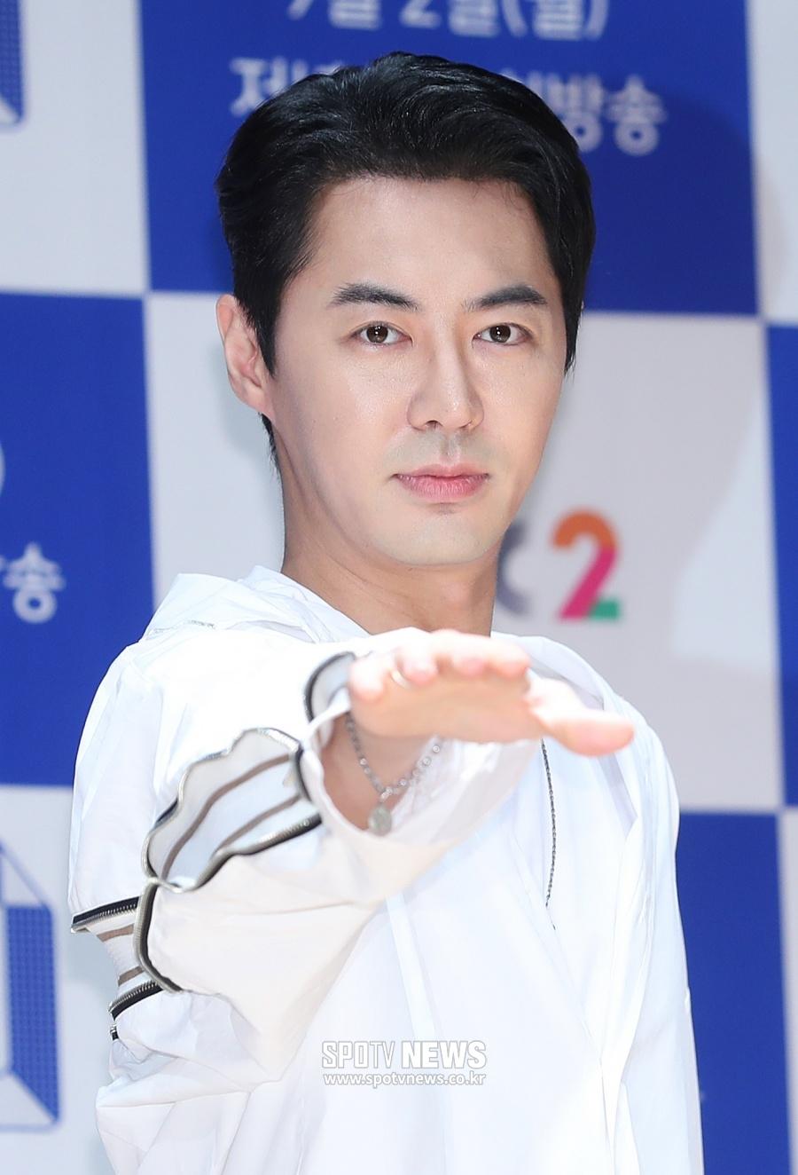 韓国の人気グループ神話のメンバー、チョンジンが白い服を着て手を伸ばしている様子。