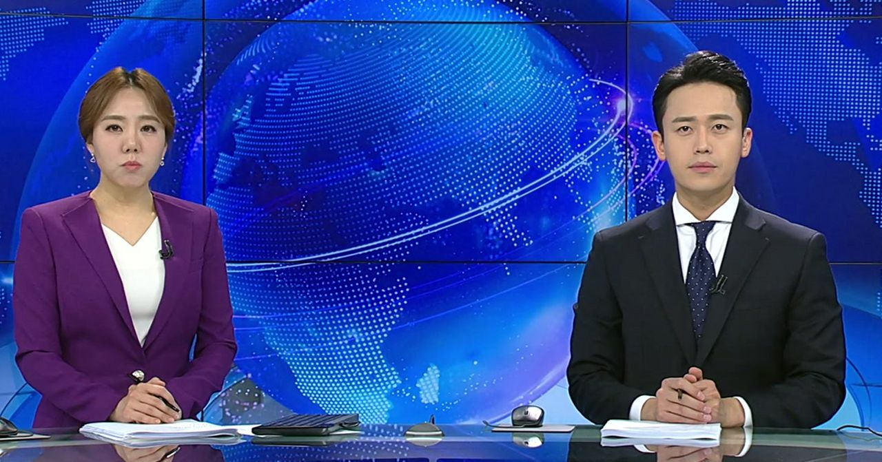 韓國電視新聞主播的播報現場，他們正在報導最新消息。