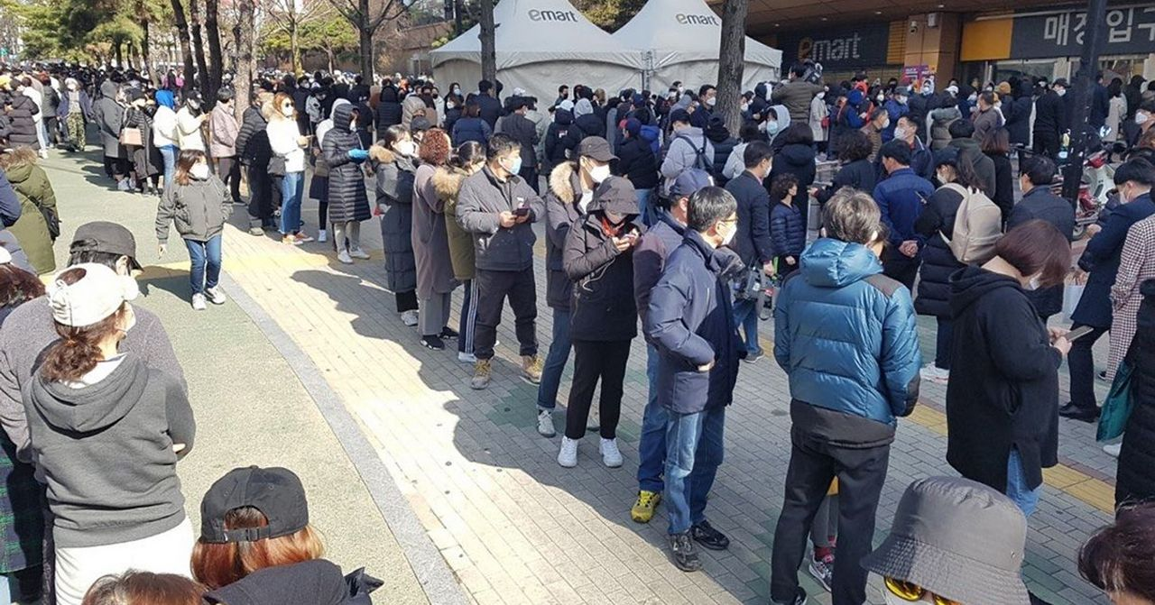 韓國蘆葦市場外排隊民眾等待購買口罩，由於疫情影響而出現長蛇陣，顯示人們對防疫用品的需求增長。
