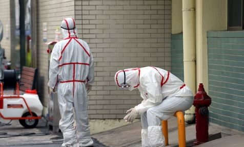 穿著防護服的工作人員在大邱街道執行消毒任務以對抗疫情。