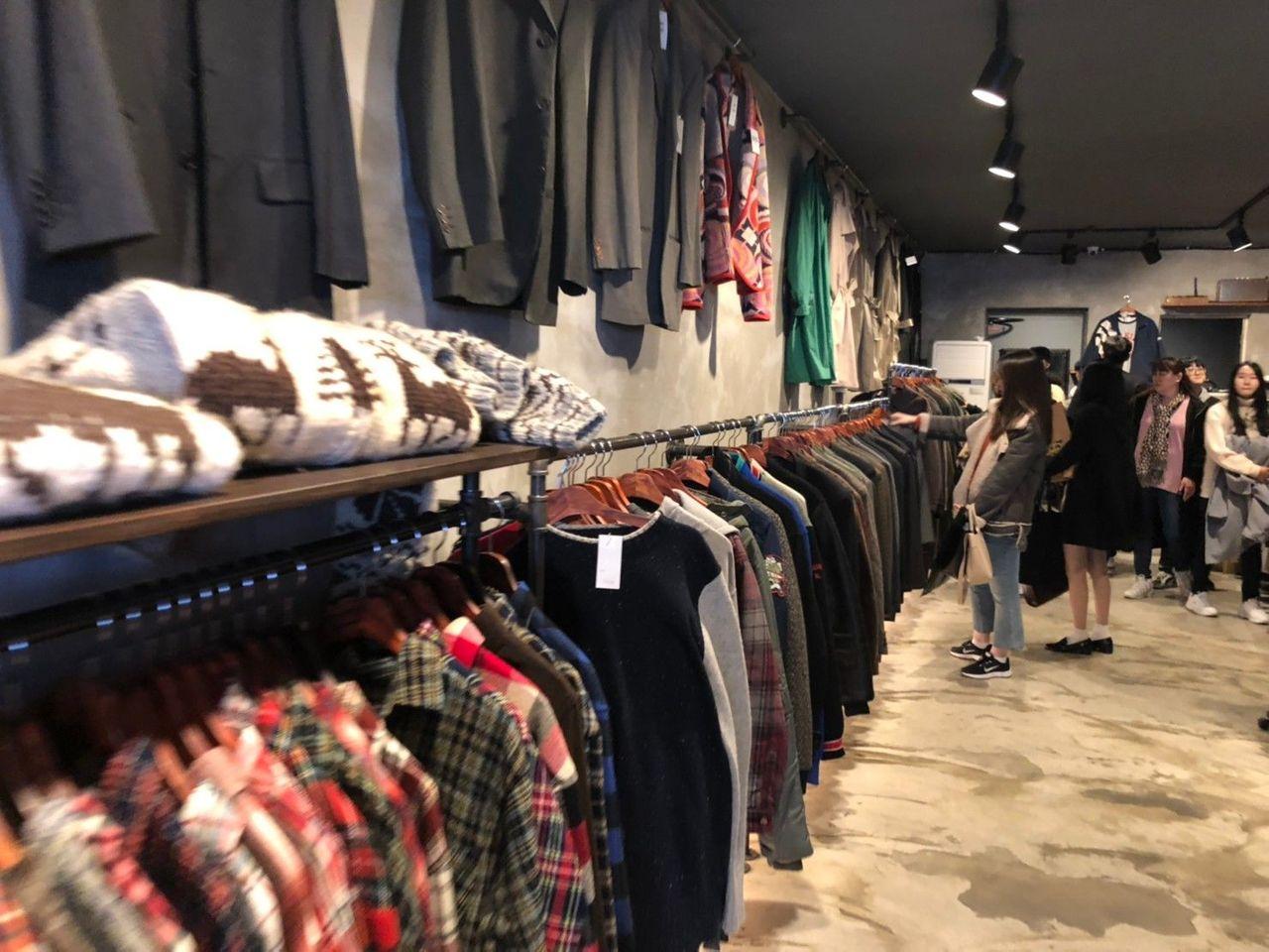 ภาพของร้านขายเสื้อผ้าวินเทจในตลาดนัดโซลพร้อมผู้คนเดินเลือกซื้อสินค้า