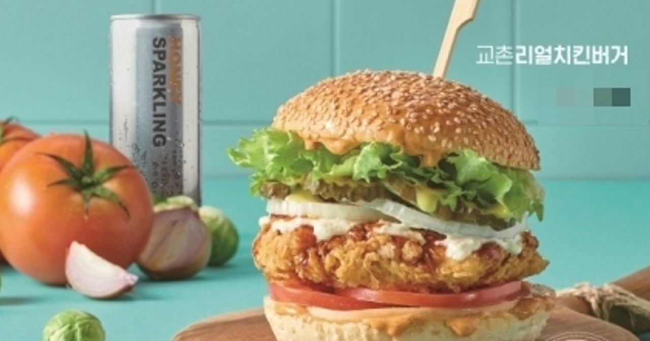 香脆誘人的橋村炸雞漢堡，搭配新鮮蔬菜，完美滿足口腹之慾，旁邊還有一瓶氣泡飲料，增添整體風味。