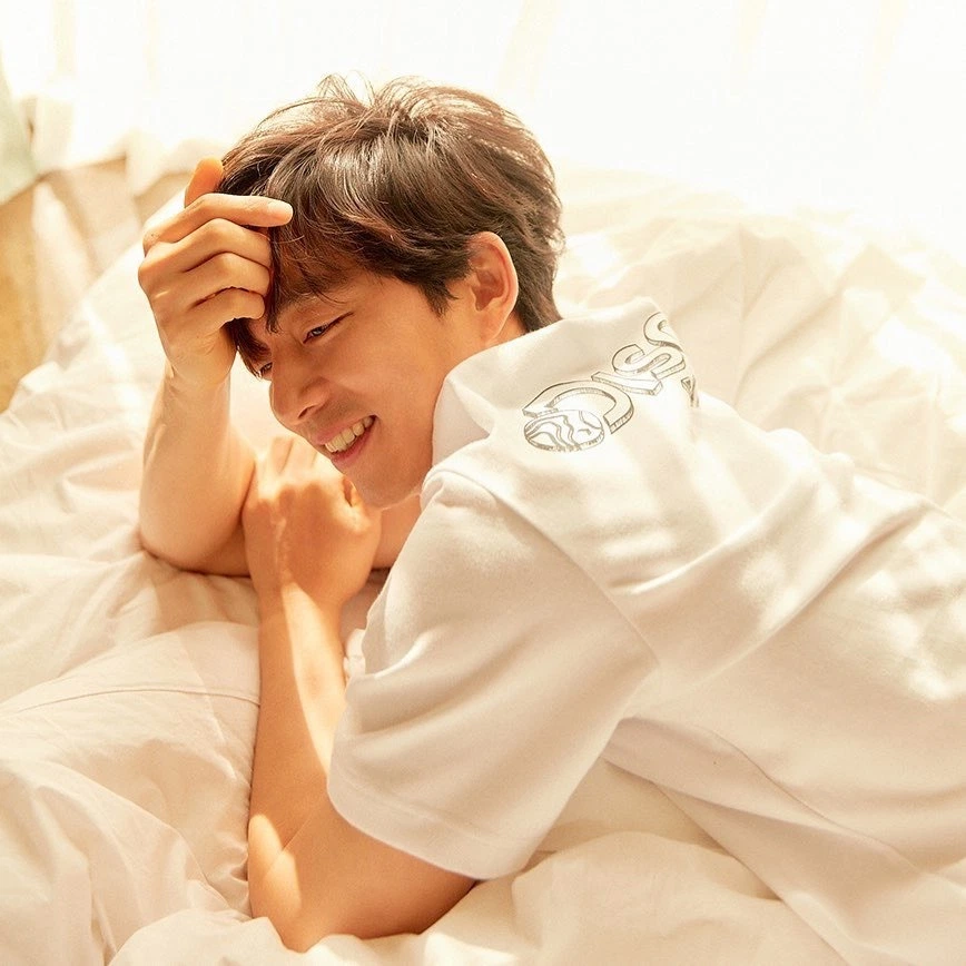 身穿白色家居服的孔刘，慵懒坐卧在床上，晨光嬉影突显出他的温暖居家魅力，Discovery品牌精神展露无遗。